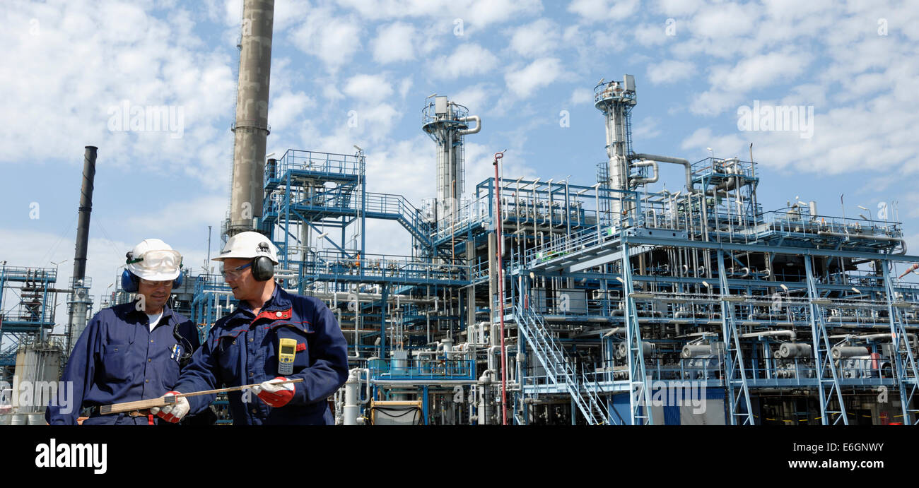 Il petrolio e il gas dei lavoratori con la raffineria in background Foto Stock