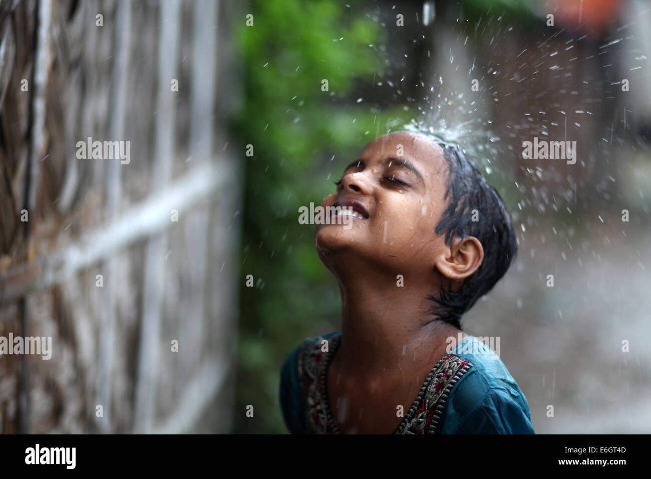 Dacca in Bangladesh. 23 Ago, 2014. Baraccopoli bambini godendo la pioggia a Dhaka.Dacca è la seconda più vulnerabili alla città di gravi inondazioni tra nove città costiere globalmente e rimarrà tale fino al 2100 a meno che le misure volte a contrastare la minaccia sono presi, uno studio internazionale suggerisce di credito: Zakir Hossain Chowdhury/ZUMA filo/Alamy Live News Foto Stock