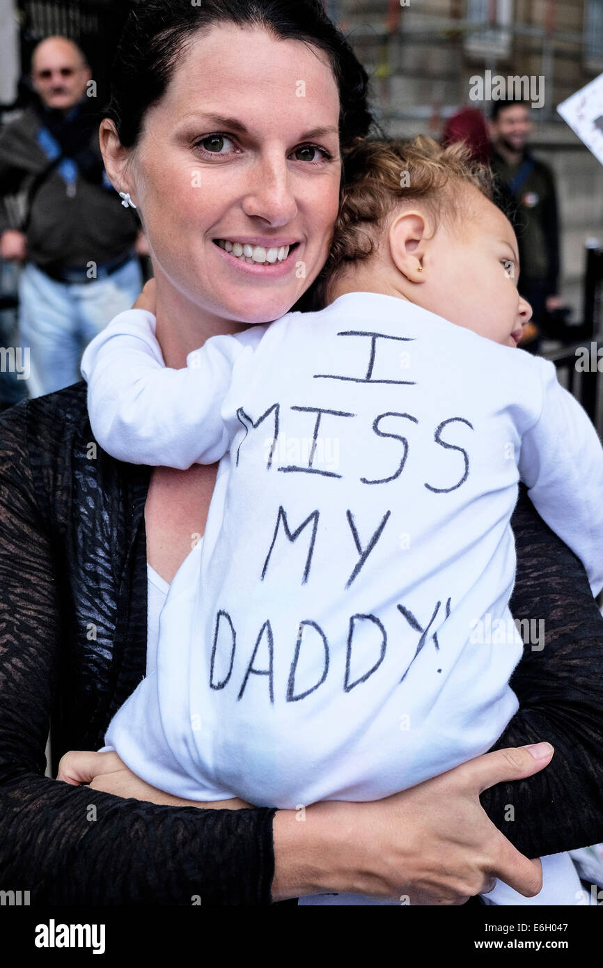 Londra, Regno Unito. 23 Agosto, 2014. Sarah Angelina tiene i suoi 1 yr old figlia Ada a una dimostrazione di protesta contro il governo norme sulla migrazione di famiglia. Queste norme introducono un nuovo minimo-soglia di reddito di £ 18.600 per "sponsorizzare l'insediamento nel Regno Unito di un coniuge o partner di non-SEE nazionalità. Ada il padre è ancora nella Repubblica Dominicana e in grado di viaggiare nel Regno Unito per essere con la moglie e il bambino della figlia. Credito: Gordon Scammell/Alamy Live News Foto Stock