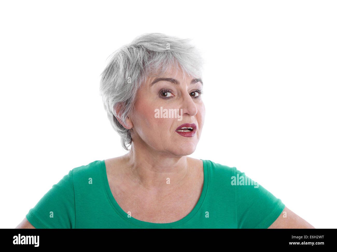 Isolato deluso donna matura indossando camicia verde cercando arrabbiato e di dubbio. Foto Stock