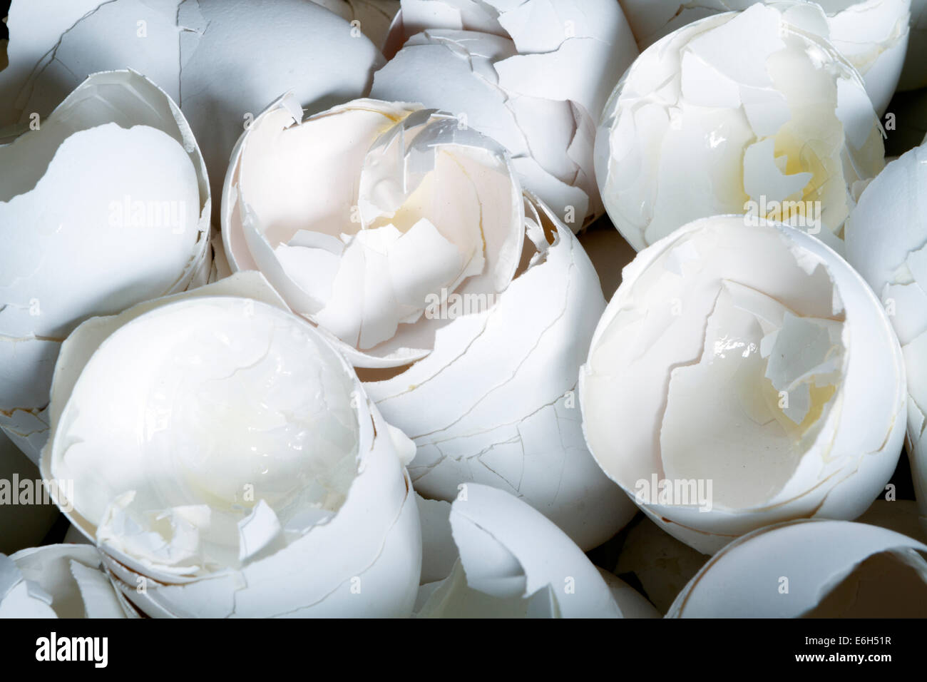 Una inquadratura ravvicinata di un grande mucchio di bianco di gusci di uova che sono incrinati aperto, impiegati nella preparazione dei prodotti alimentari e quindi scartato. Foto Stock