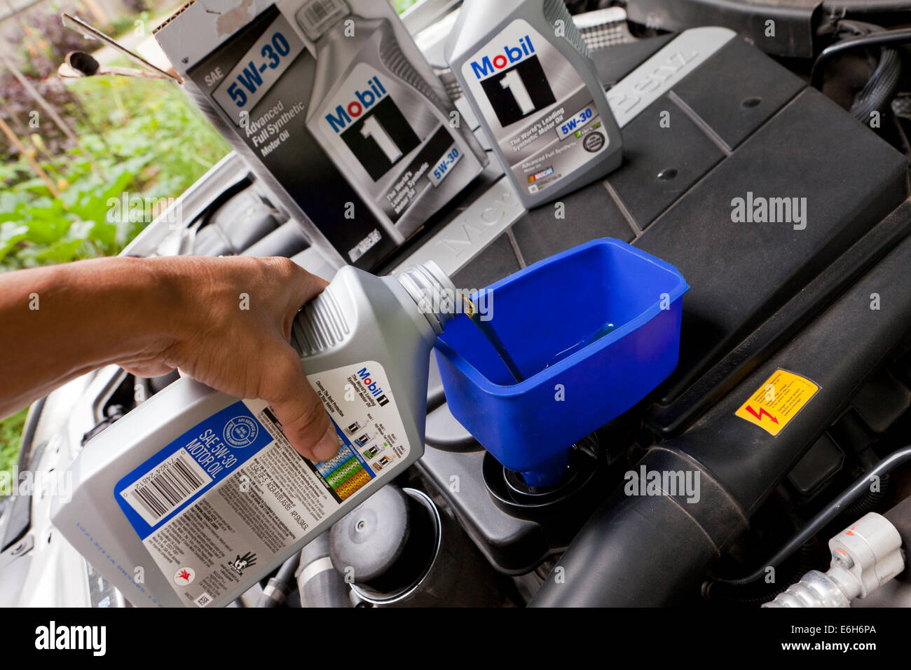 Uomo Mobile versatore 1 olio motore in imbuto - USA Foto Stock