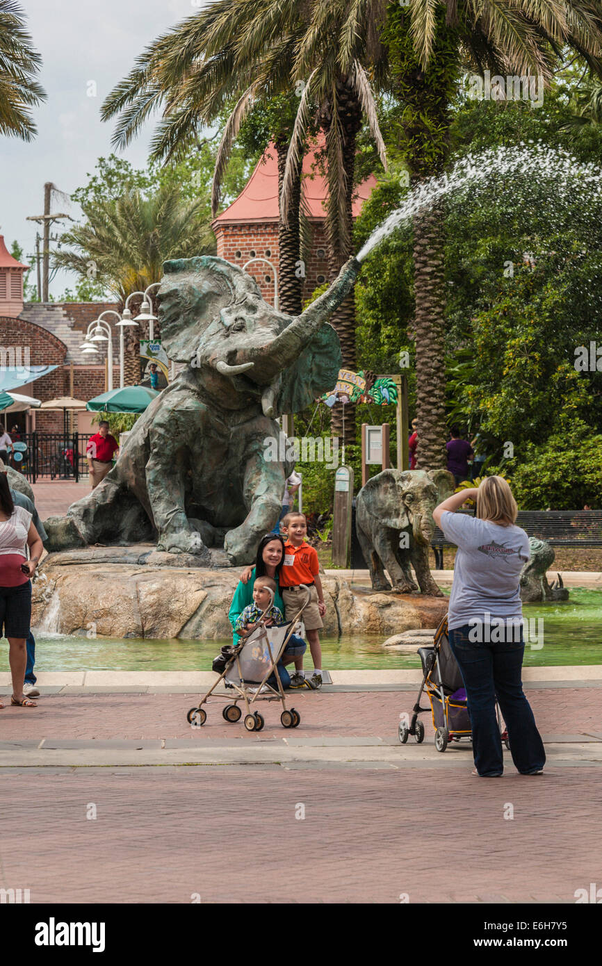 Famiglia di scattare le foto di fronte alla fontana dell'elefante in Audubon Zoo, New Orleans, Louisiana Foto Stock