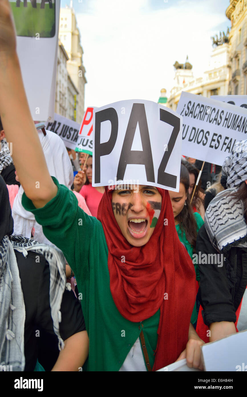 Giovane donna esigente e pace per protestare contro gli attacchi israeliani nella Striscia di Gaza nel corso di una manifestazione a Madrid il 18 luglio Foto Stock