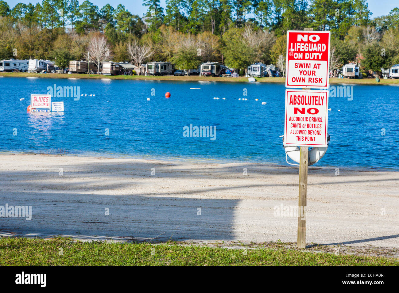 Segni avvisa di nuoto a proprio rischio nel lago sul lago Flamingo Resort RV a Jacksonville, Florida Foto Stock