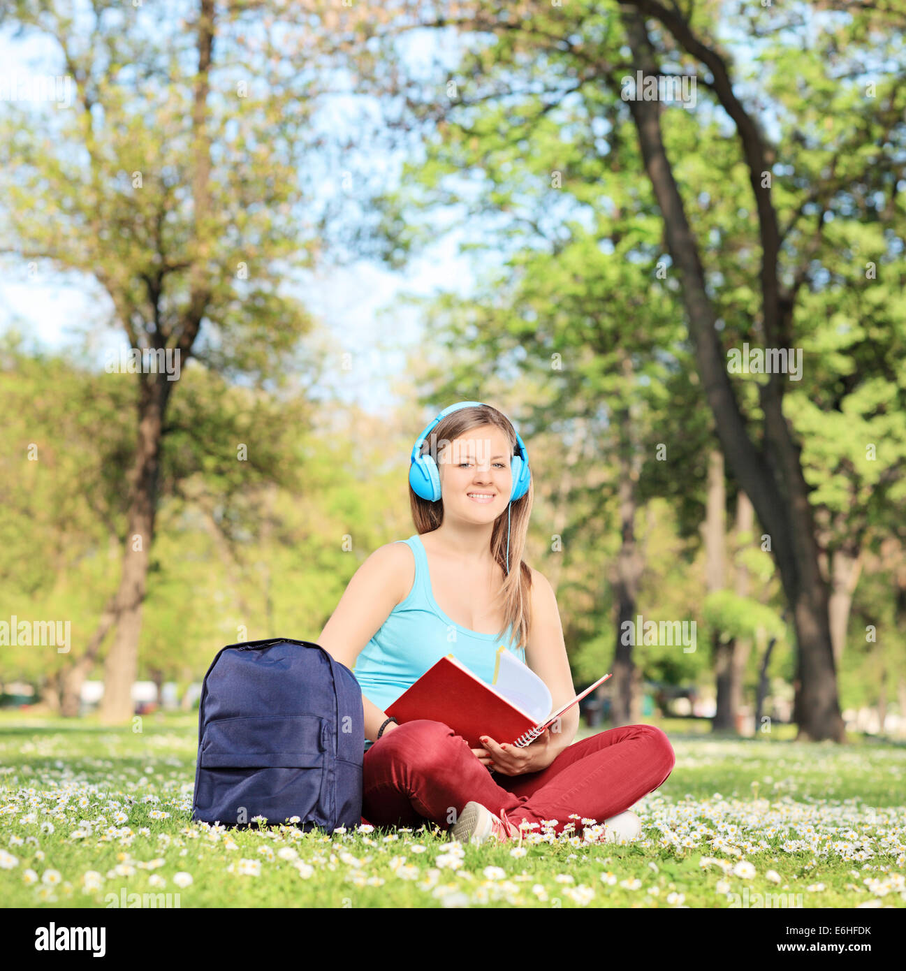 Donna di apprendimento su campus seduti in un prato pieno di fiori Foto Stock