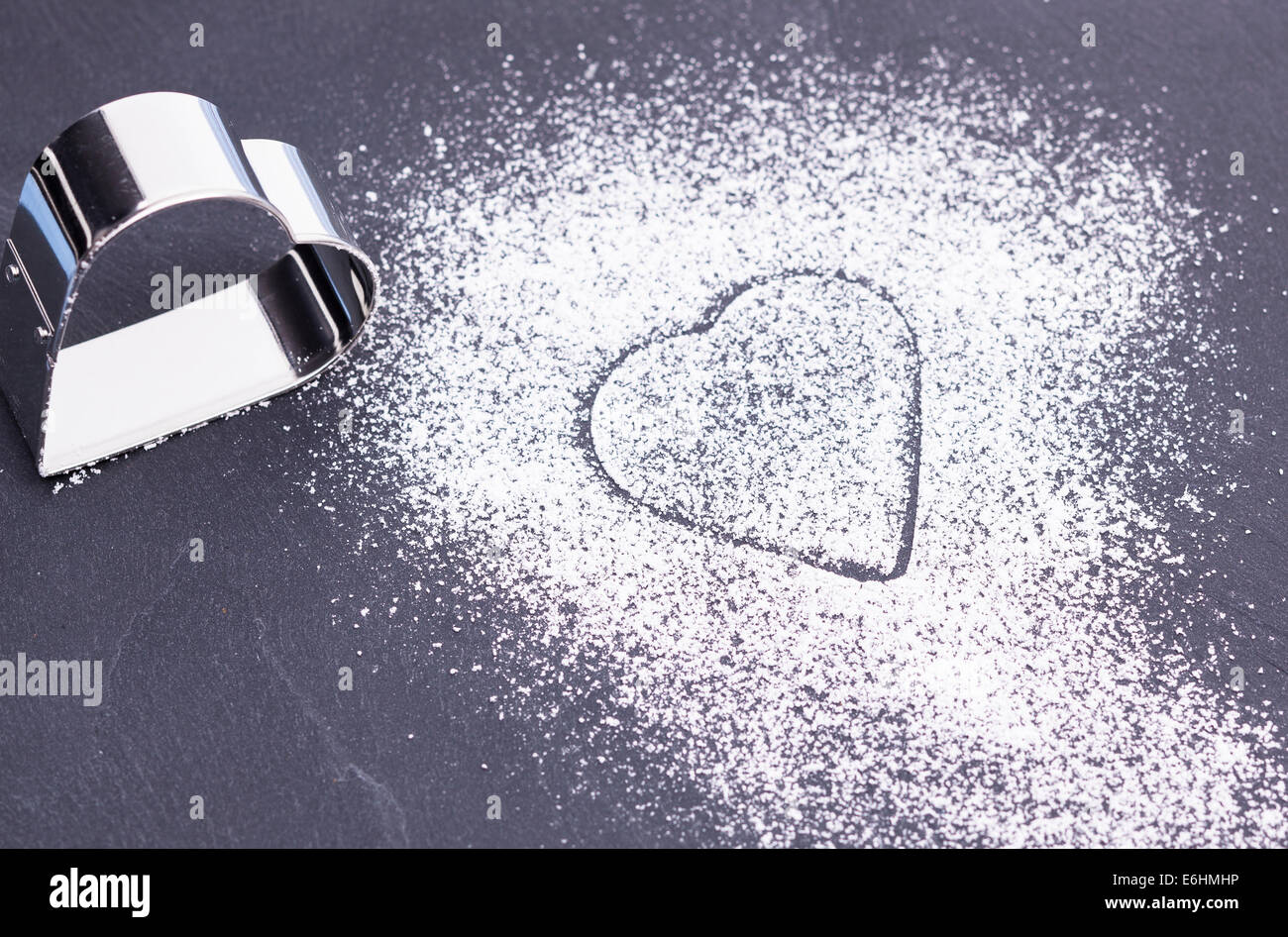 L'immagine mostra un lo zucchero in polvere di cuore su una lastra grigia Foto Stock