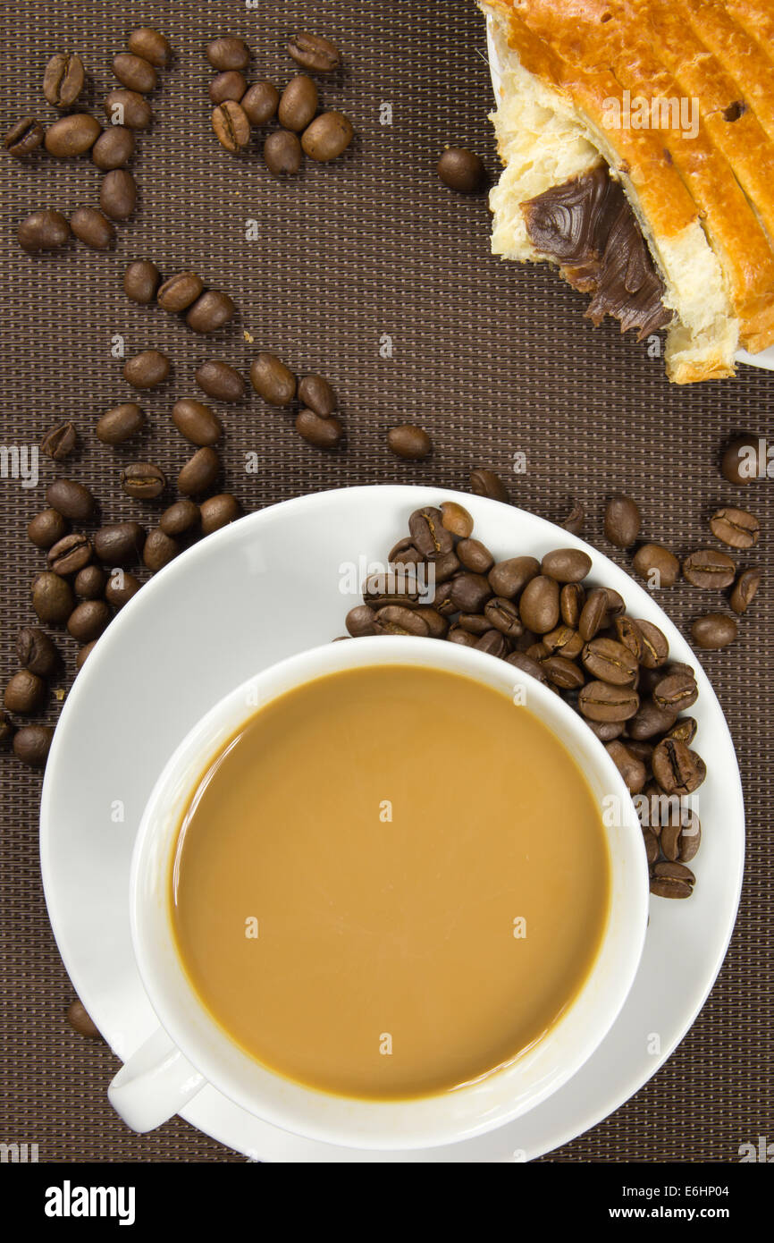 Tazza di caffè e cioccolato francese croissant su sfondo marrone Foto Stock