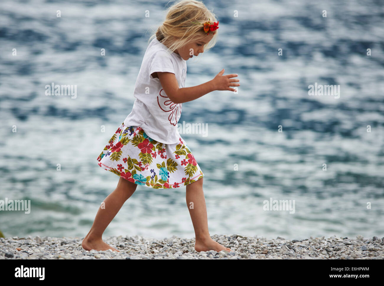 Bambino ragazza bionda giocando e passeggiate in riva al mare con il  livello del mare sullo sfondo Foto stock - Alamy
