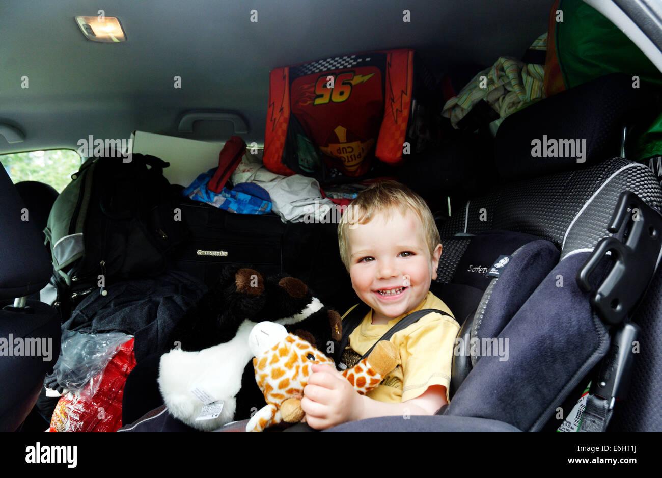 Un giovane ragazzo in un molto piena auto del giorno ci siamo spostati house Foto Stock