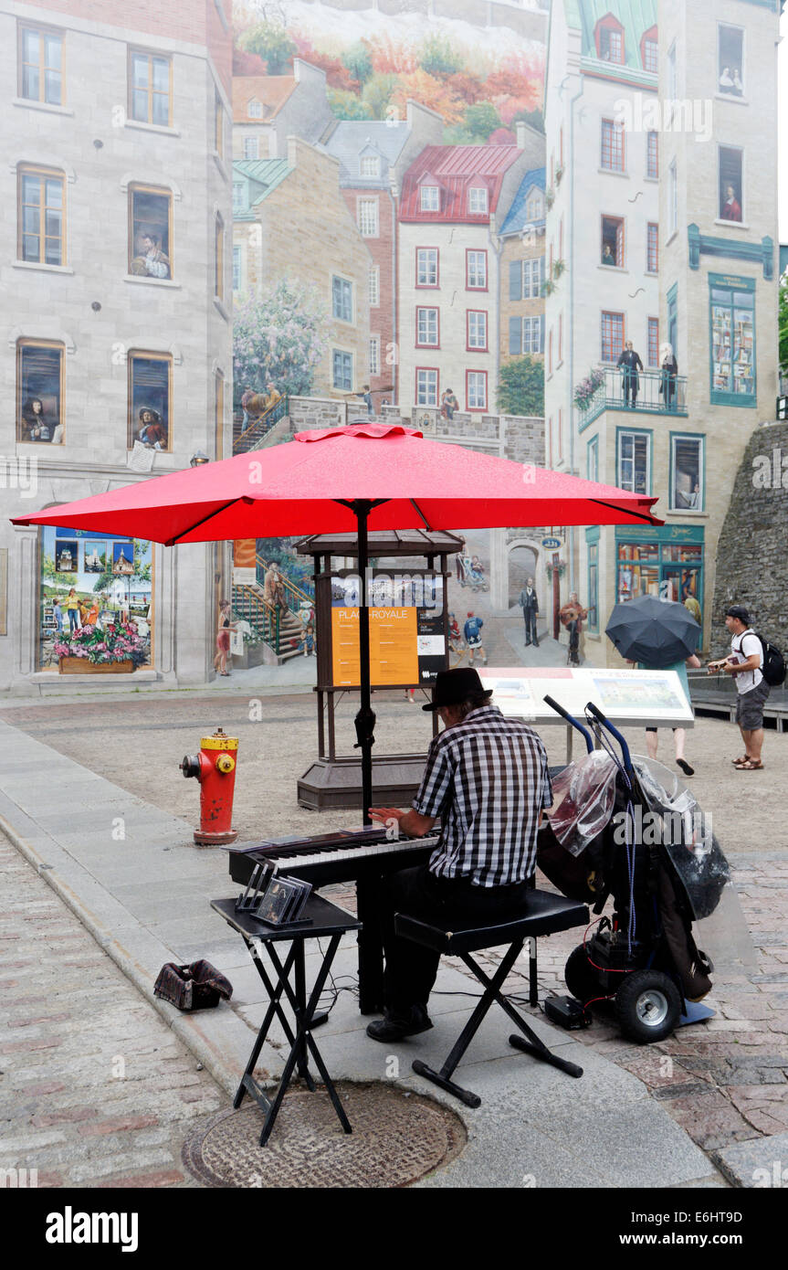 Un organo giocatore giocare da una grande parete murale in Quebec City, in Canada Foto Stock