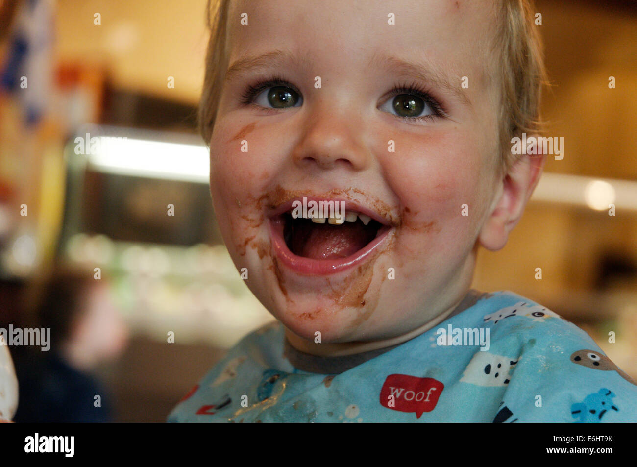 Due anni di vecchio con salsa di cioccolato in tutto il suo volto Foto Stock