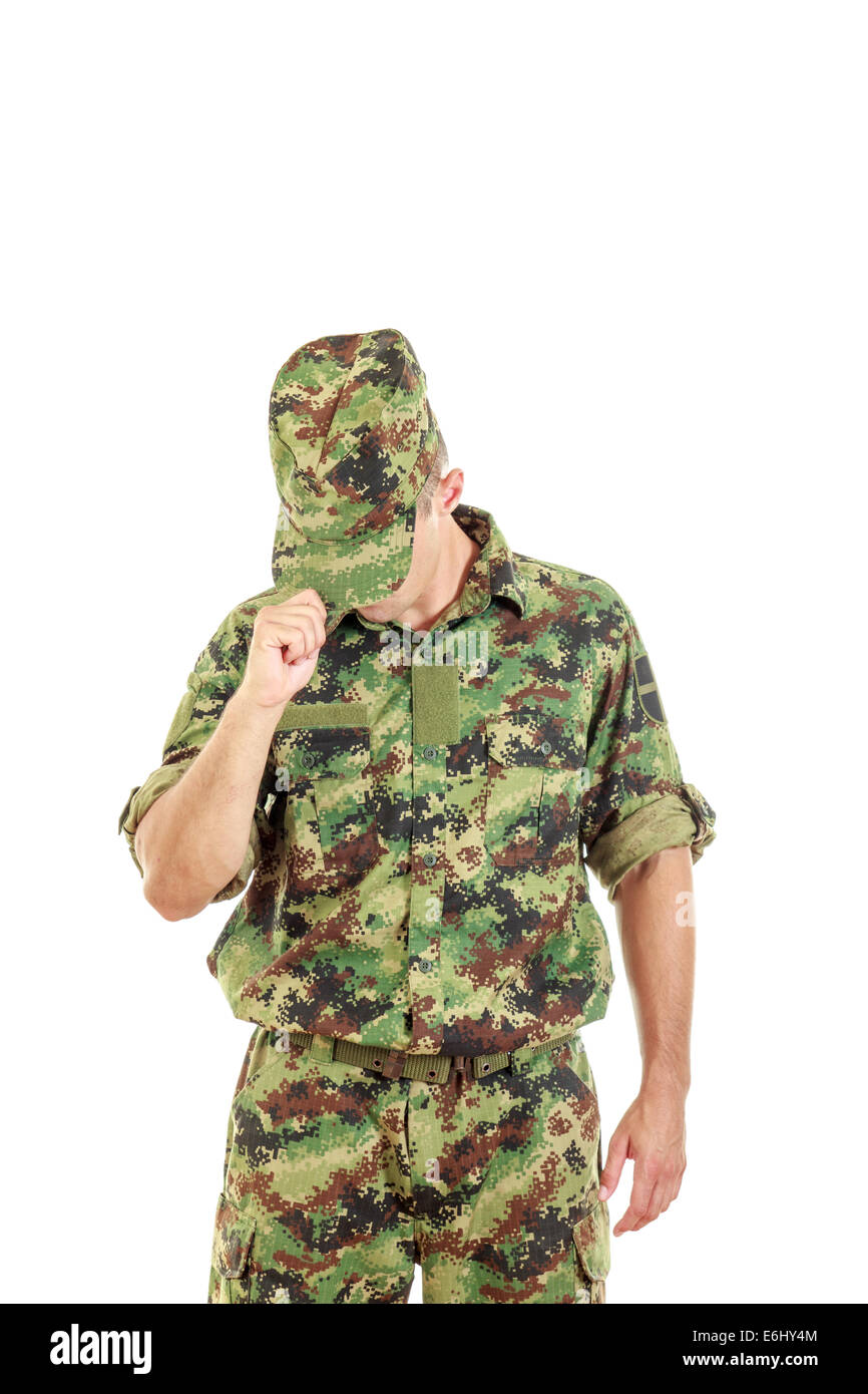 Un soldato sconosciuto con la faccia nascosta nel verde uniforme di mimetizzazione copre la faccia con il cappuccio e in piedi Foto Stock