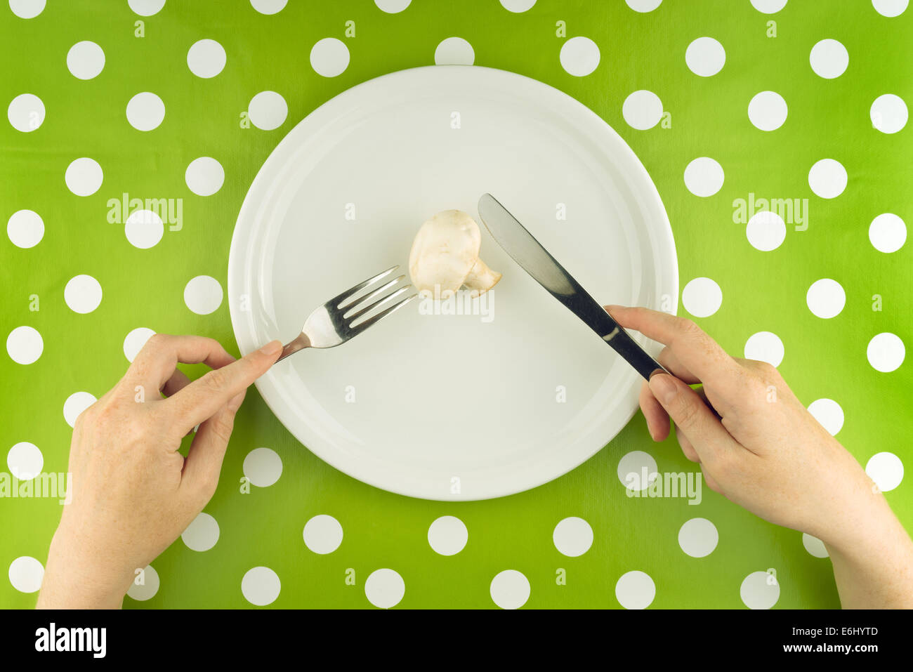 Donna di mangiare fresche Portabello commestibile Fungo Champignon su una piastra bianca, vista dall'alto. Foto Stock