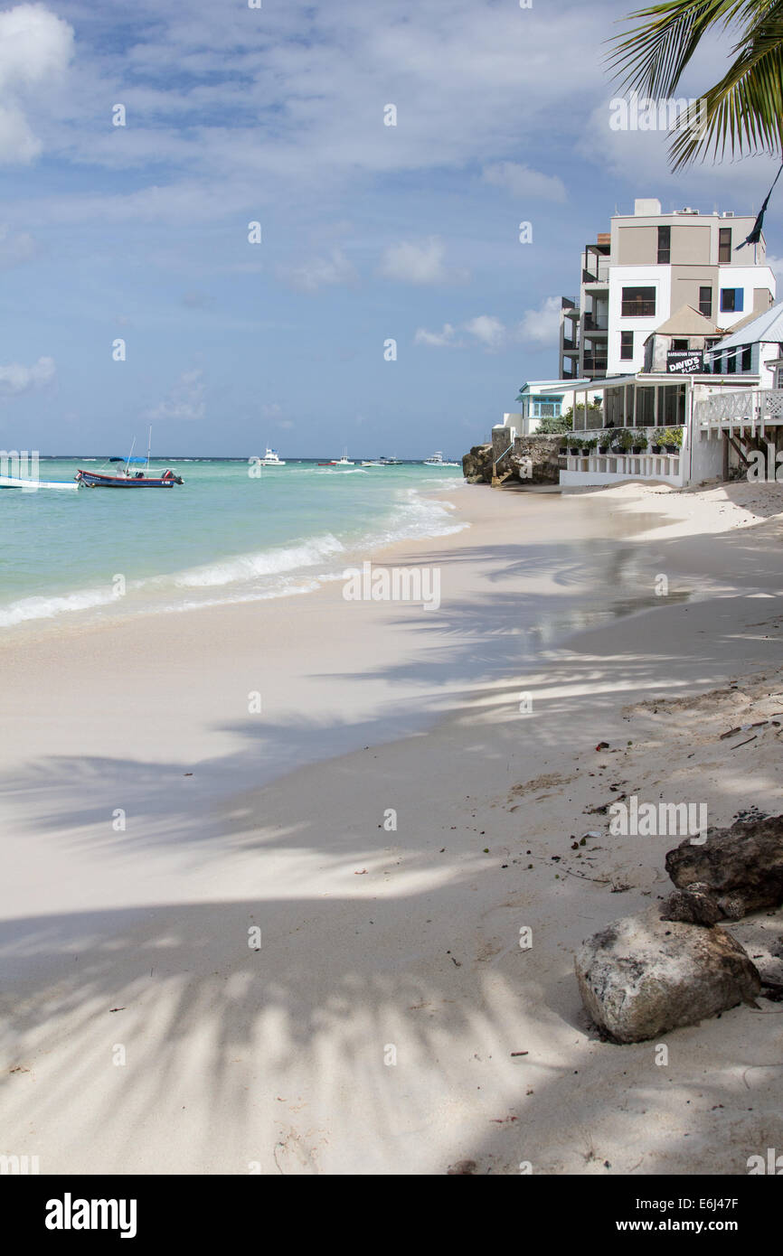 Vista della spiaggia di St Lawrence Gap Barbados con il blu del cielo e le piccole barche in mare. Davids posto per pranzare delle Barbados anche visibile Foto Stock