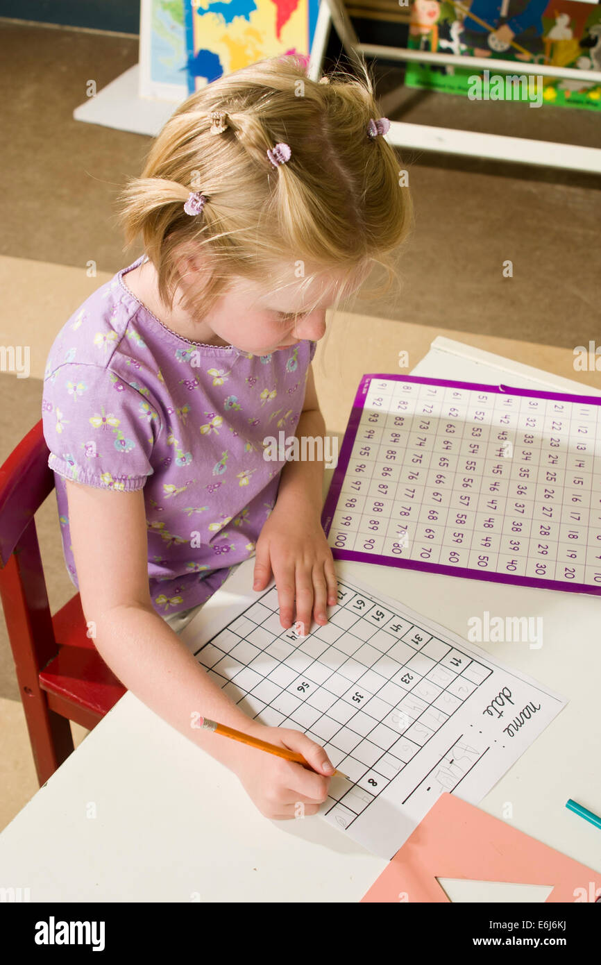 4-5 anni anni ragazza caucasica gli studenti lavorare duro sulle operazioni aritmetiche in aula al tavolo al signor © Myrleen Pearson Foto Stock