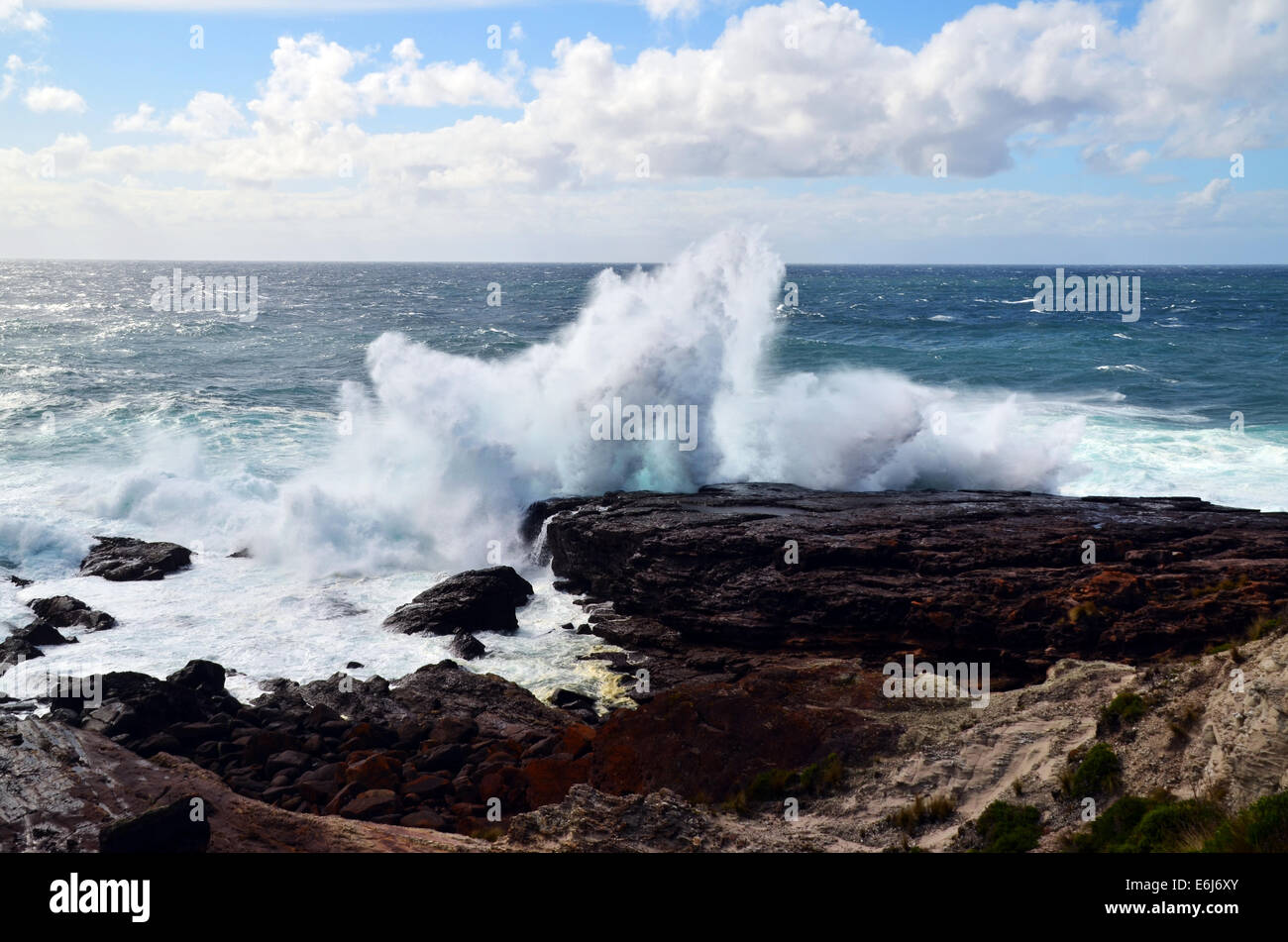 Onde che si infrangono contro le rocce sulla linea costiera Foto Stock