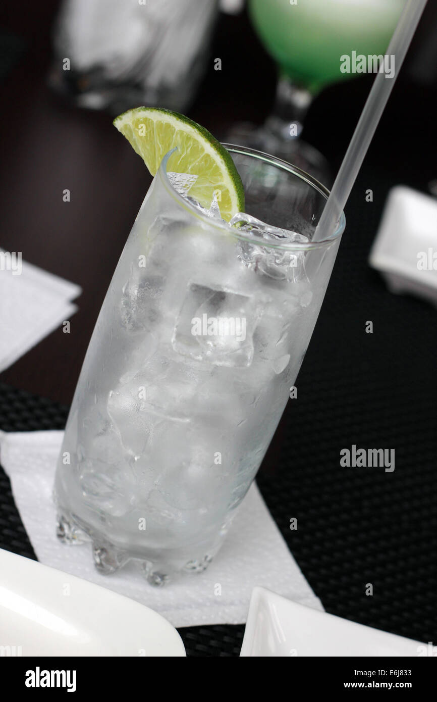 Bicchiere vuoto con ghiaccio e limone pronto per essere servito con una bevanda. Foto Stock