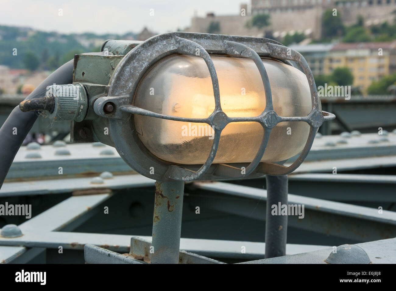 Rivestiti di metallo incandescente lampada attaccata alla ringhiera del ponte Foto Stock