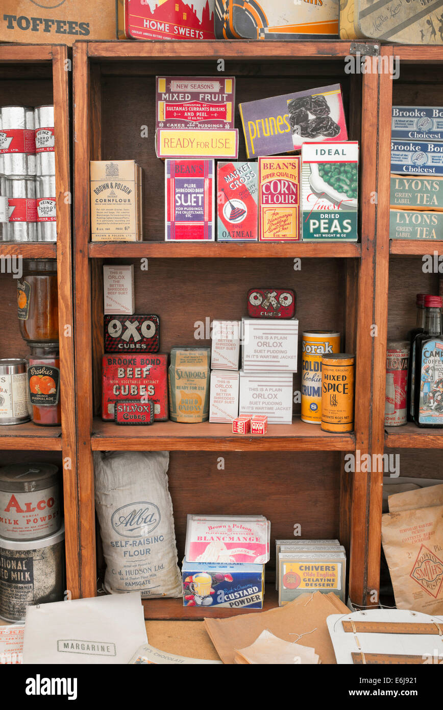 1940s replica fruttivendolo con pacchetti di cibo e articoli per la casa su ripiani in corrispondenza di una storica rievocazione militare show. Regno Unito Foto Stock 1940s replica fruttivendolo con pacchetti di cibo e articoli per la casa su ripiani in corrispondenza di una storica rievocazione militare show. Regno Unito Foto Stock