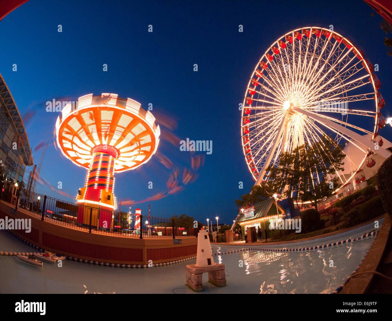 Una notte, Vista fisheye del popolare Wave Swinger e ruota panoramica Ferris giostre a Navy Pier di Chicago. Foto Stock