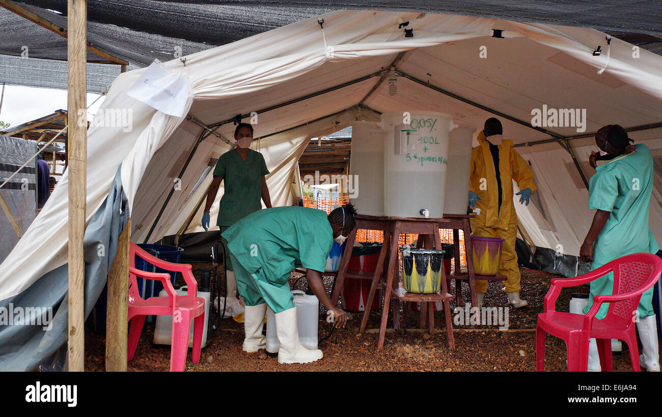 Volontari sanitari e medici stranieri suit fino in abbigliamento protettivo come si preparano per disinfettare le case di vittime di Ebola Agosto 2, 2014 in Kailahun, Sierra Leone. Foto Stock