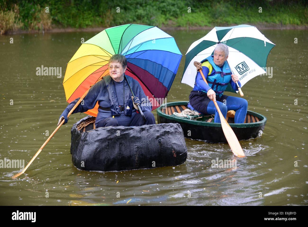 Wet Weather: pioggia battente per l'Ironbridge Coracle Regata come Wendy Gee di Nantwich e Jane Pearce di Teignouth riparo sotto la loro brollies in attesa di competere sul fiume Severn Credito: David Bagnall/Alamy Live News Foto Stock