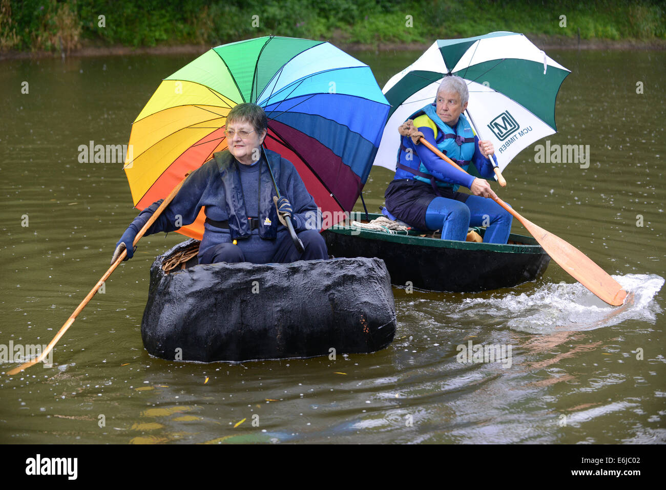 Meteo: pioggia battente per l'Ironbridge Coracle Regata come Wendy Gee di Nantwich e Jane Pearce di Teignouth riparo sotto la loro brollies in attesa di competere sul fiume Severn Credito: David Bagnall/Alamy Live News Foto Stock