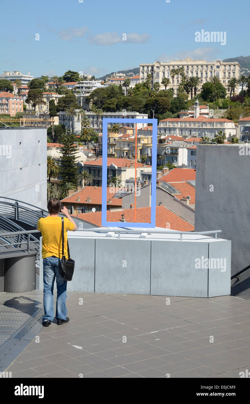 Visitatore turistico o sulla terrazza sul tetto del museo di arte moderna Mamac con vista di Cimiez e la Città Vecchia di sfondo delle Alpi Marittime di Nizza Francia Foto Stock