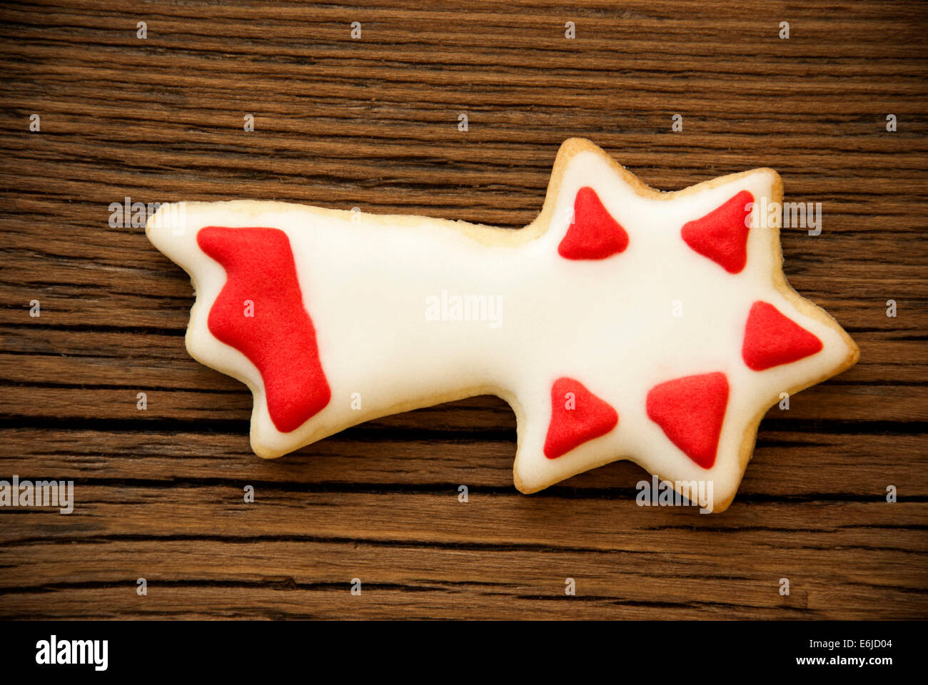 Una stella cadente Cookie con il bianco e il rosso della decorazione su legno Foto Stock