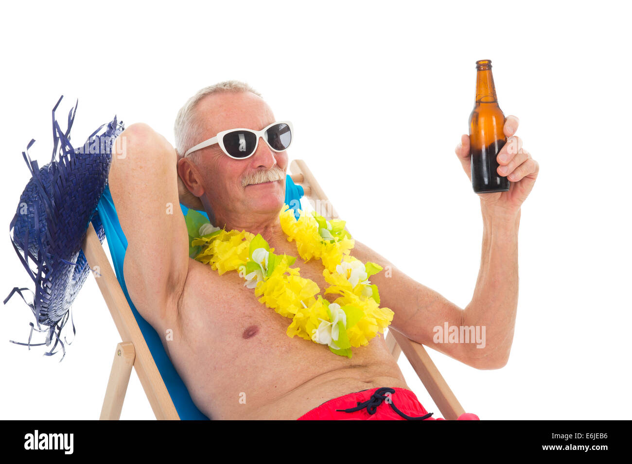 Uomo in pensione in vacanza in seduta sdraio sulla spiaggia a bere