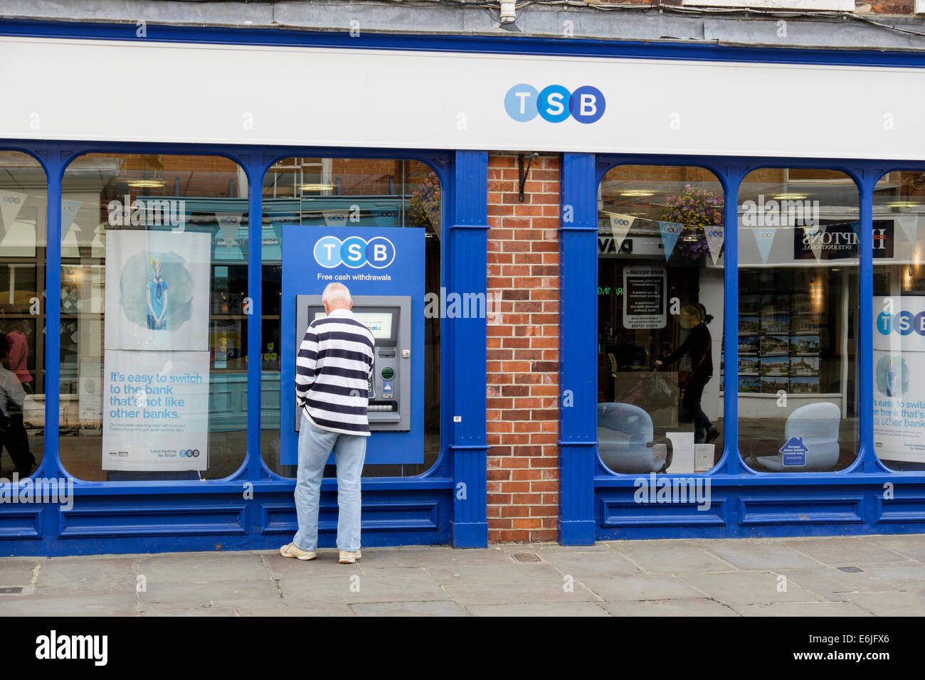 Il cliente utilizza un bancomat bancomat ATM al di fuori di un ramo del TSB Bank. East Street, Chichester, West Sussex, in Inghilterra, Regno Unito, Gran Bretagna Foto Stock