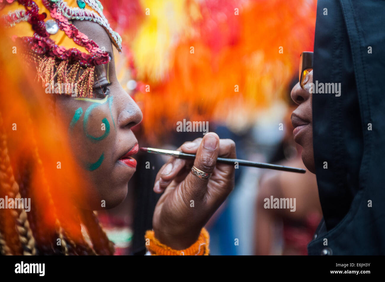 Londra, Regno Unito. 25 Ago, 2014. Un reveller ha il suo make up done durante il carnevale di Notting Hill a Londra. Credito: Piero Cruciatti/Alamy Live News Foto Stock