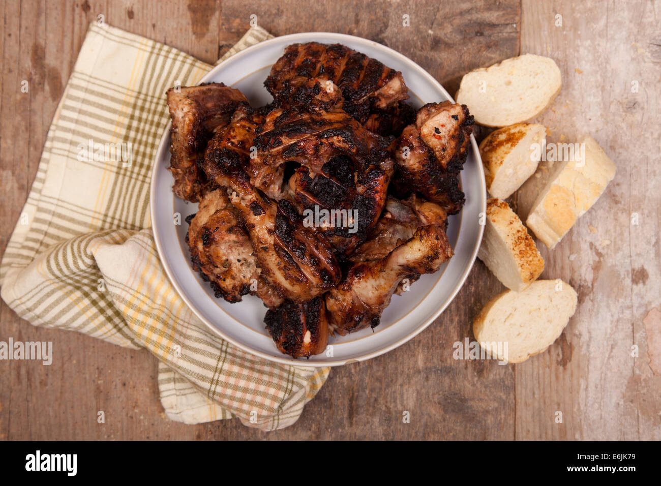 Grigliata di pollo jerk nel recipiente di argilla sul tavolo di legno Foto Stock