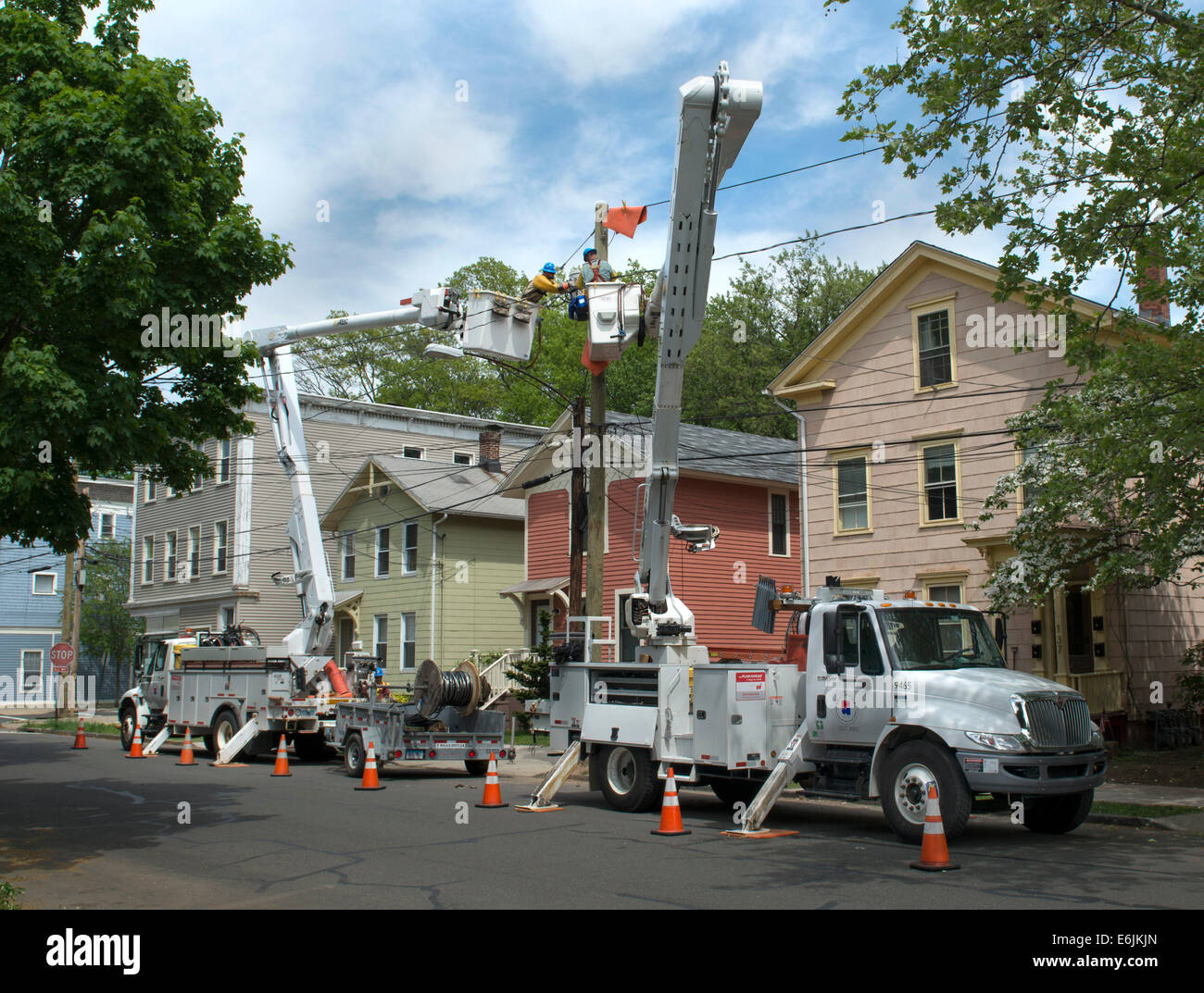 Elettricisti utilizzare cherry picker di autocarri per il lavoro di installare nuove linee elettriche in New Haven, CT. Foto Stock