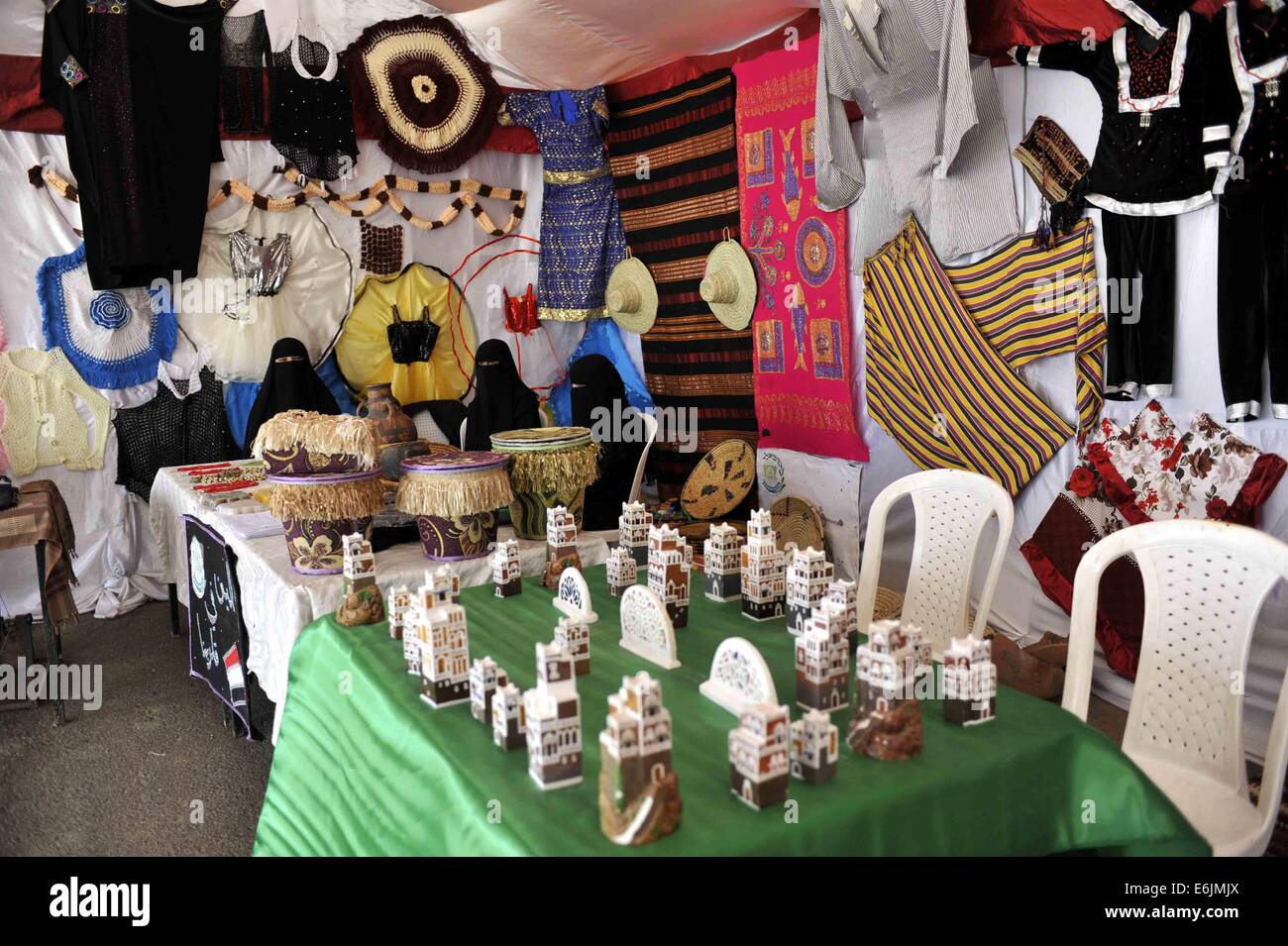 Sanaa, Yemen. 25 Ago, 2014. Le donne yemenite sedersi in un negozio di attesa per i clienti ad acquistare il tradizionale souvenir fatti a mano durante il termine di una settimana di Sanaa Summer Festival a Sanaa, Yemen, su agosto 25, 2014. Lo Yemen ha lanciato il 7° Sanaa Summer Festival nella capitale Sanaa. Le autorità intendono recuperare il turismo nel paese arabo che ha visto i disordini politici e micidiali conflitti a partire dal 2011. Credito: Mohammed Mohammed/Xinhua/Alamy Live News Foto Stock