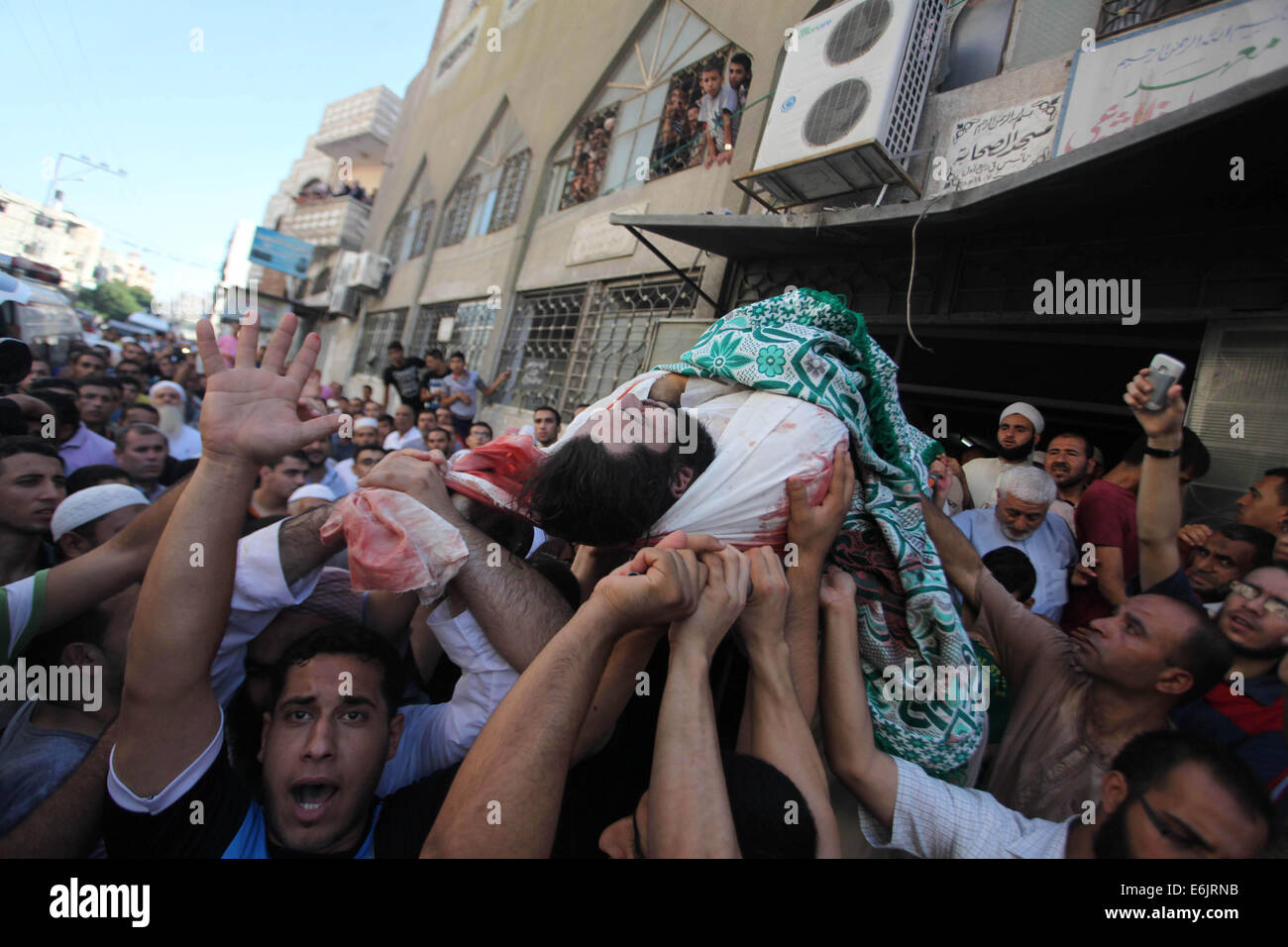 La striscia di Gaza City, nella Striscia di Gaza. 25 Ago, 2014. Lutto palestinese portano il corpo di Basim Hijazi 36, dopo che la sua vettura è stata bersaglio di un attacco aereo israeliano anche uccidere suo fratello Ahmed, 26, e un amico durante il loro funerale. Credito: Ashraf Amra/immagini APA/ZUMA filo/Alamy Live News Foto Stock