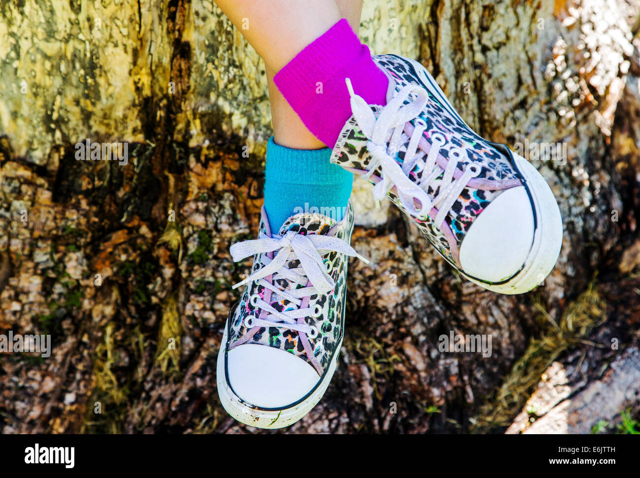 Fotografia di sette anni della ragazza sneakers colorate e di due diversi colori di calze Foto Stock