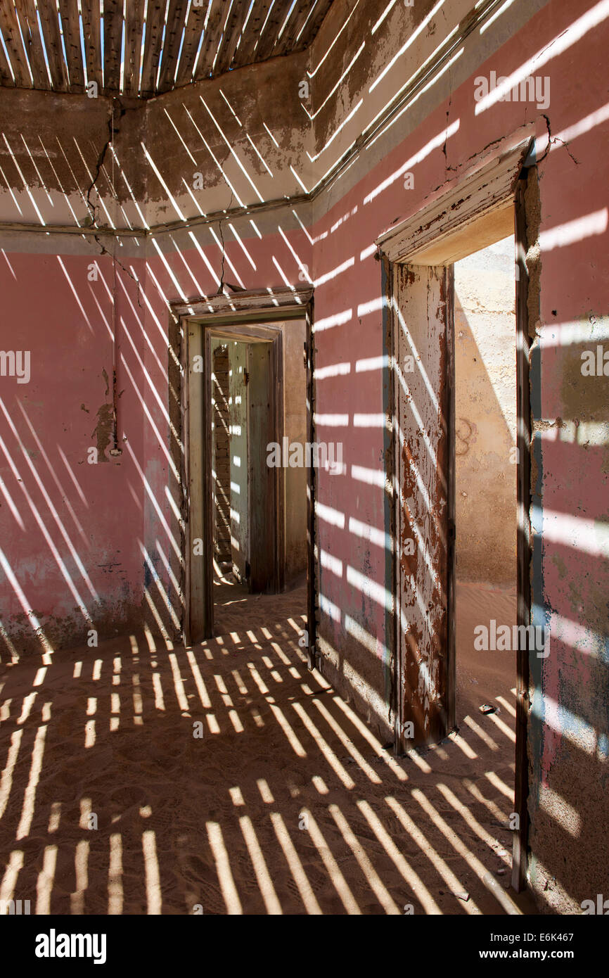 La luce che passa attraverso i listelli di una casa in decadimento nella ex minatori di diamante insediamento che viene lentamente coperta da sabbia Foto Stock