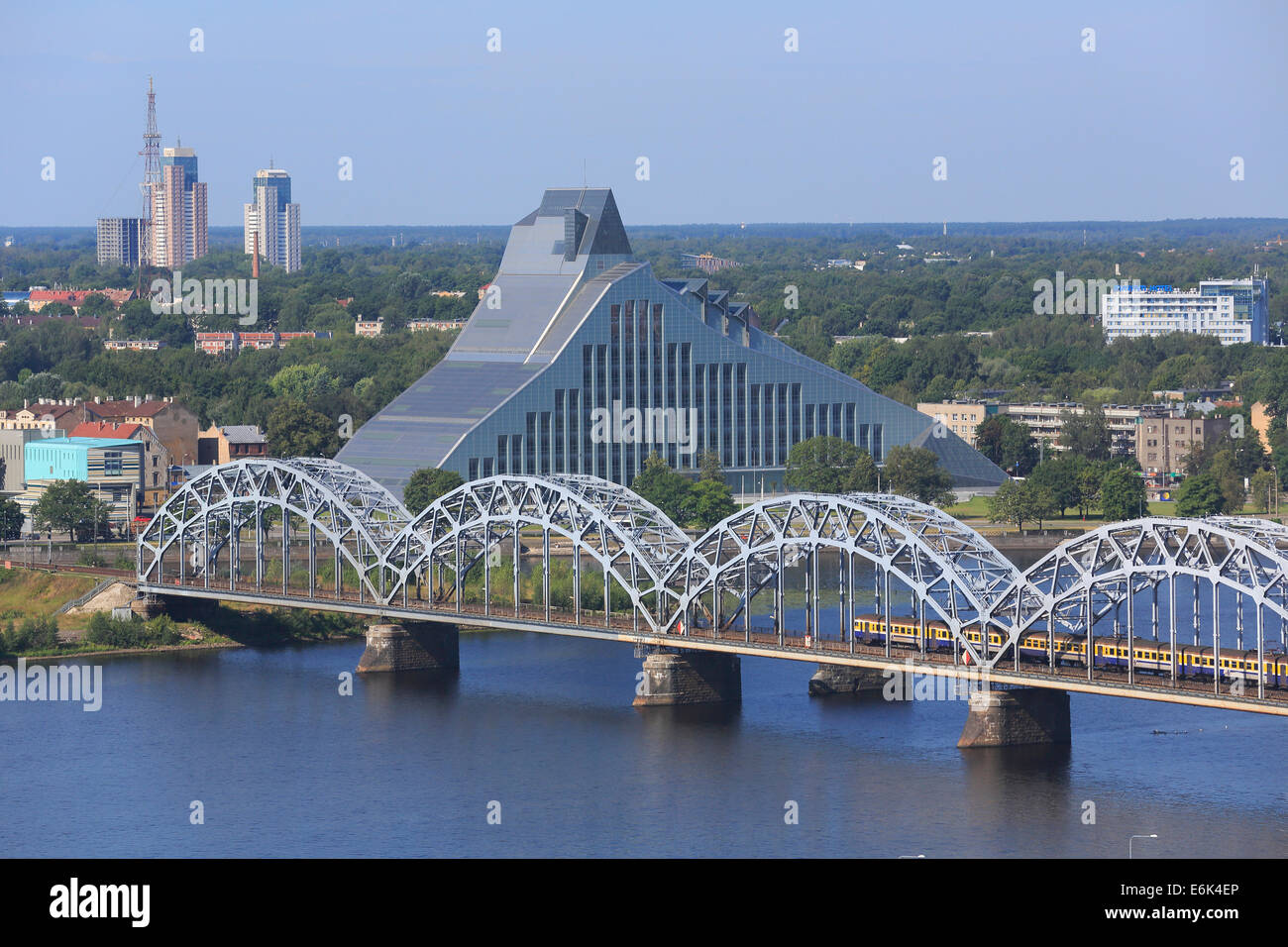 Fiume Daugava con il ponte ferroviario o Dzelzceļa si inclina e la nuova biblioteca nazionale, vista dalla torre alta del Foto Stock