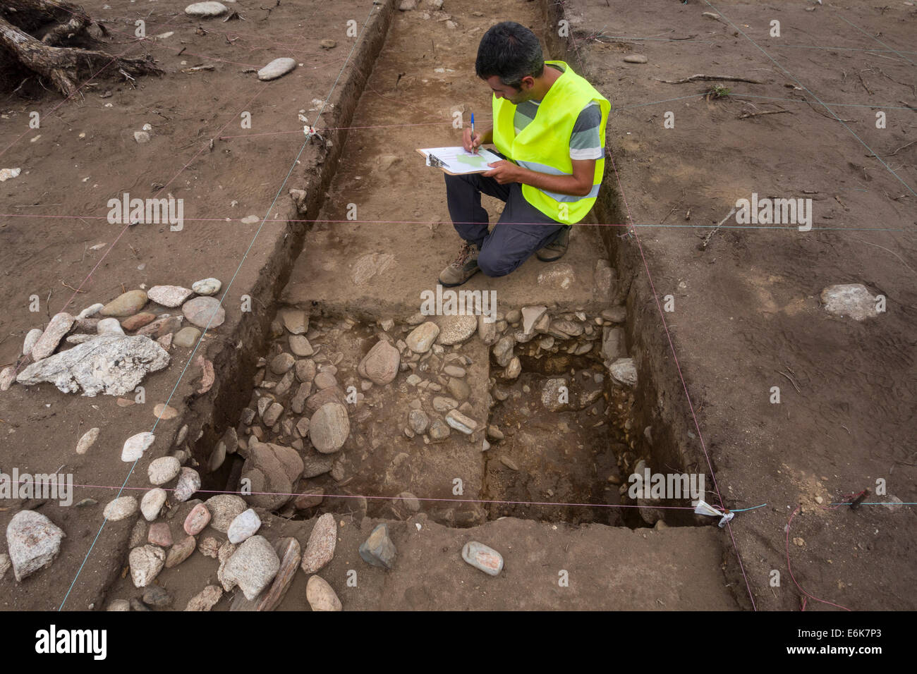 Archeologo esaminando lo scavo archeologico sito Foto Stock