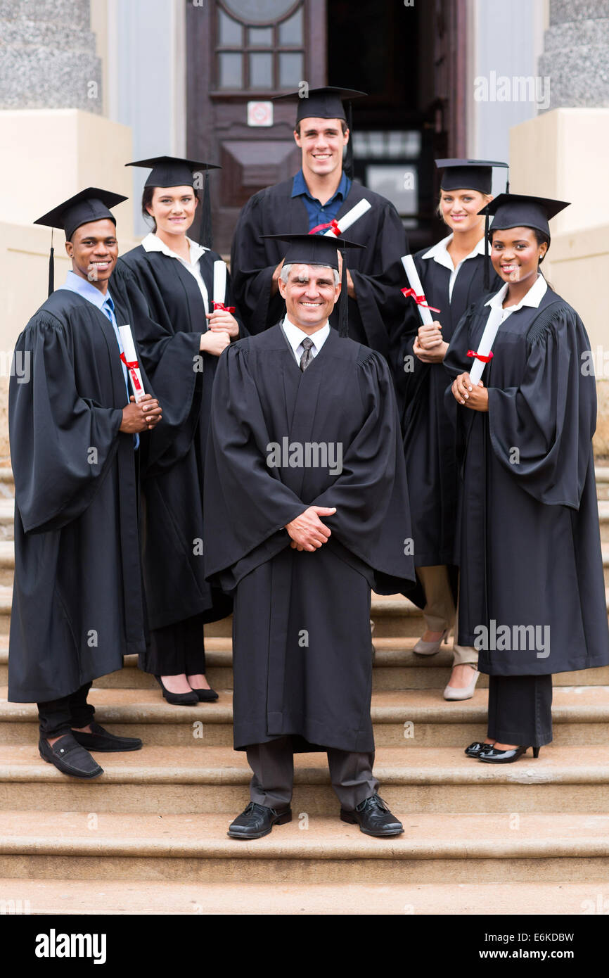 Felice professore universitario e il gruppo dei laureati alla cerimonia di consegna dei diplomi Foto Stock
