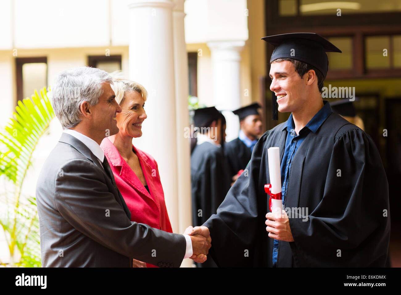 Padre orgoglioso congratularmi con suo figlio sul giorno di graduazione Foto Stock