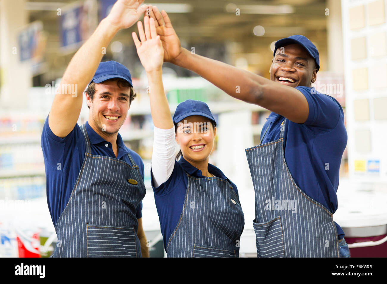 Il gruppo di allegro negozio di ferramenta di lavoratori ad alta cinque Foto Stock