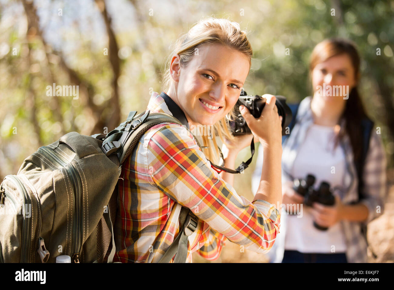 Piuttosto giovane donna di scattare le foto del suo amico in autunno mountain Foto Stock