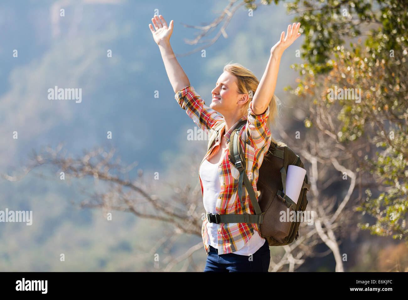Felice giovane donna con i bracci aperti sulla cima della montagna Foto Stock