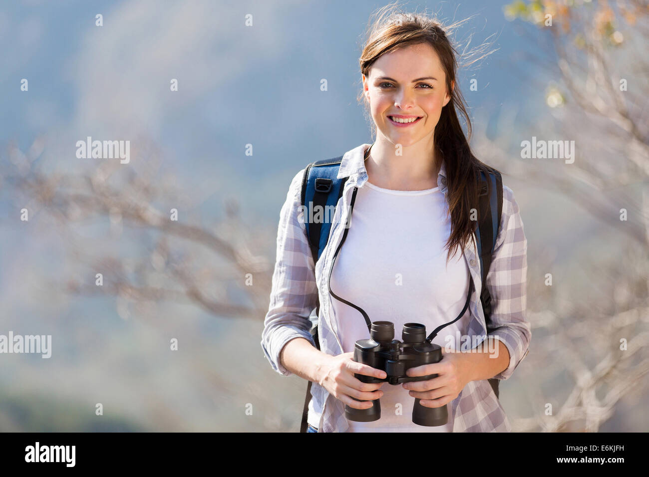 Bella giovane donna sulla cima della montagna con il binocolo Foto Stock
