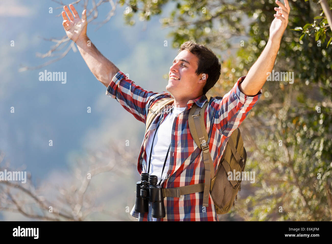 Felice giovane uomo braccia aperto sulla sommità della montagna Foto Stock
