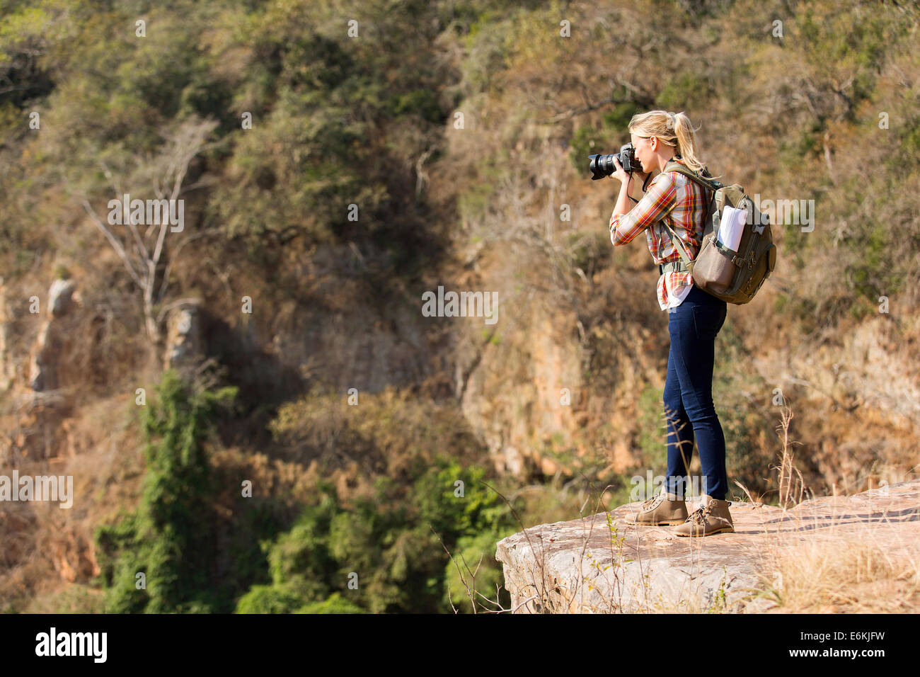 Femmina giovane fotografo di scattare le foto sulla cima della montagna Foto Stock