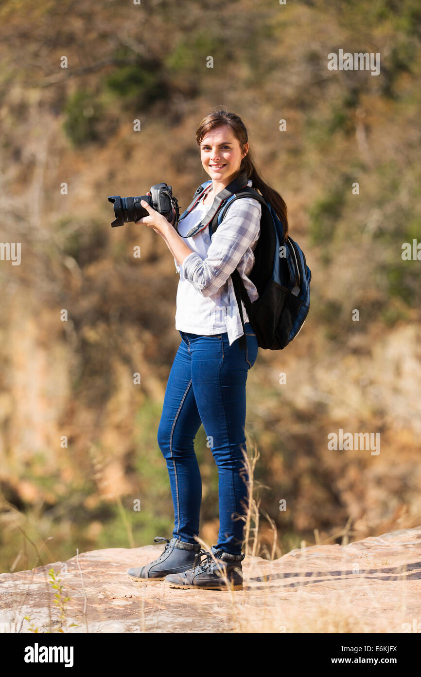 Giovani femmine escursionista permanente sulla cima della montagna con la fotocamera reflex digitale Foto Stock